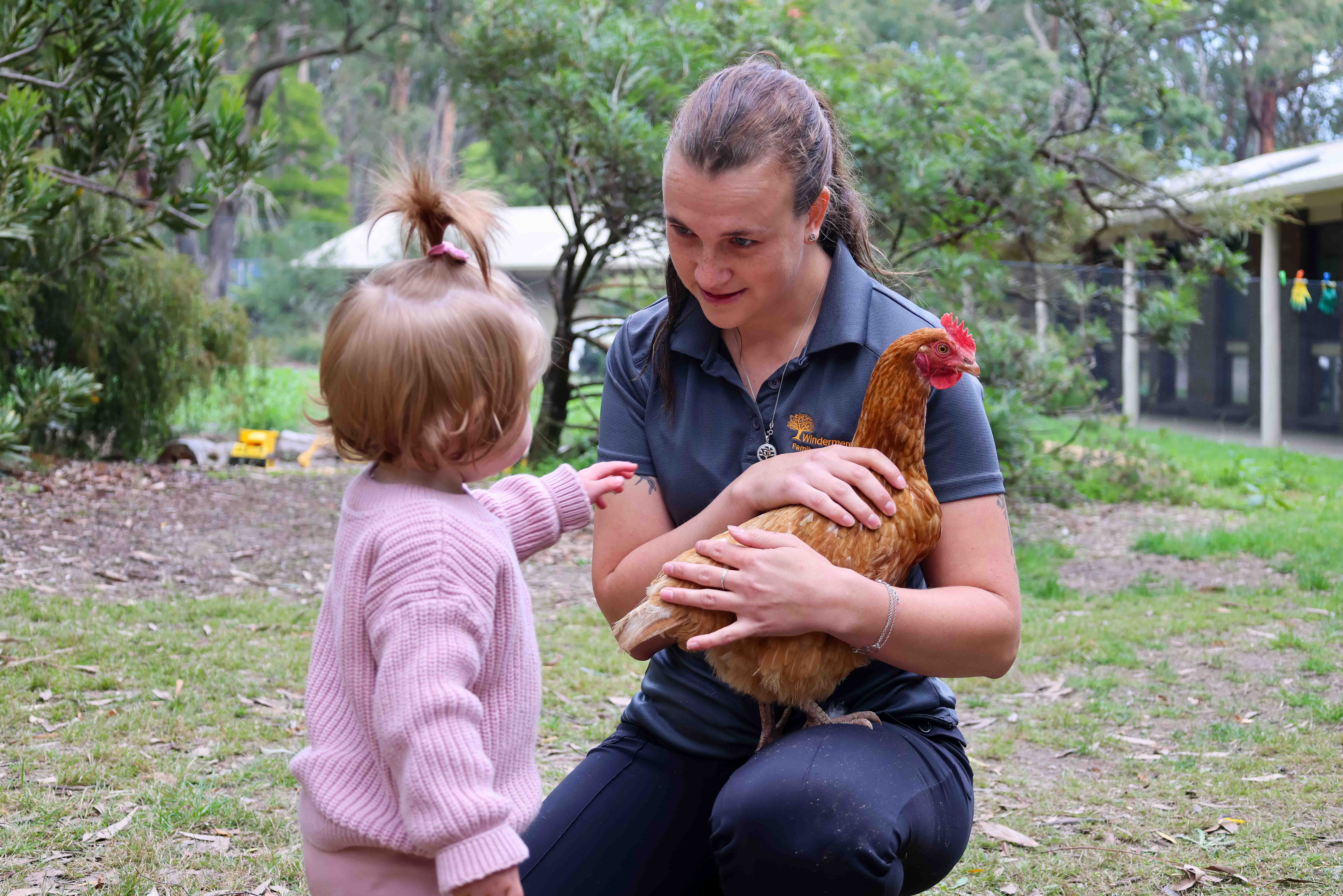 Family Day Educator Rhianna with child and pet chicken